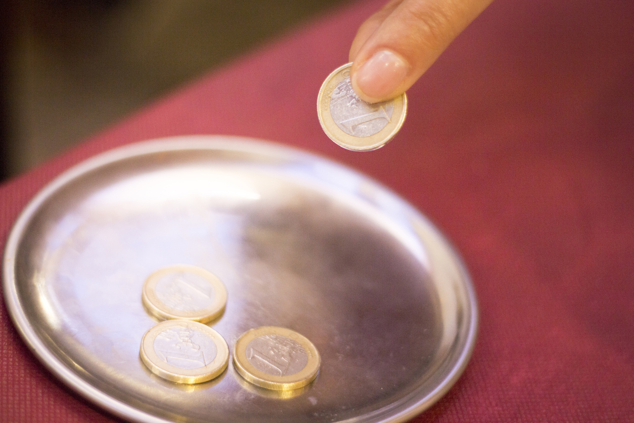 Euros coins change money in restaurant on metal tray paying meal check.