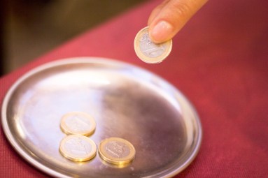 Euros coins change money in restaurant on metal tray paying meal check.
